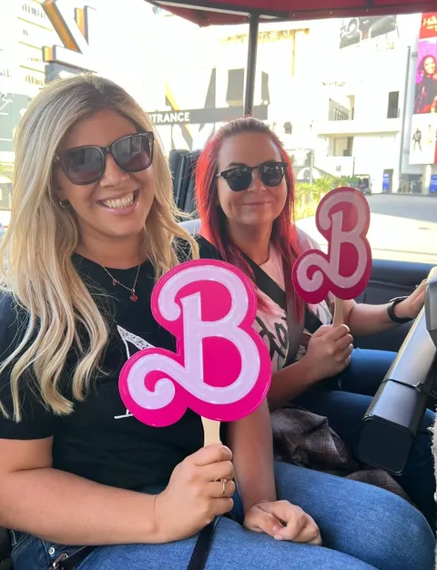 Film Freak Tours guests holding Barbie props during a themed Hollywood movie locations tour