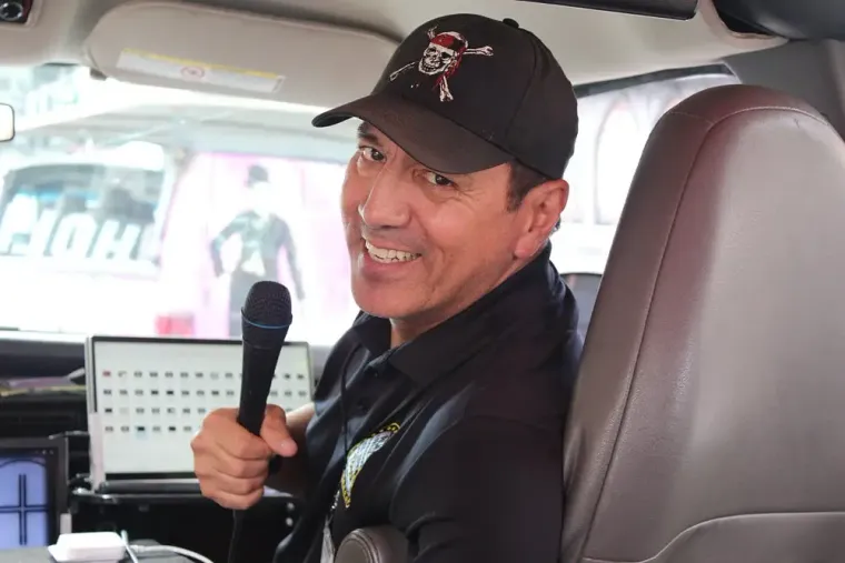 Leo Quinones hosting the Film Freak Movie Locations Tour — holding a microphone inside the tour van in Hollywood, California